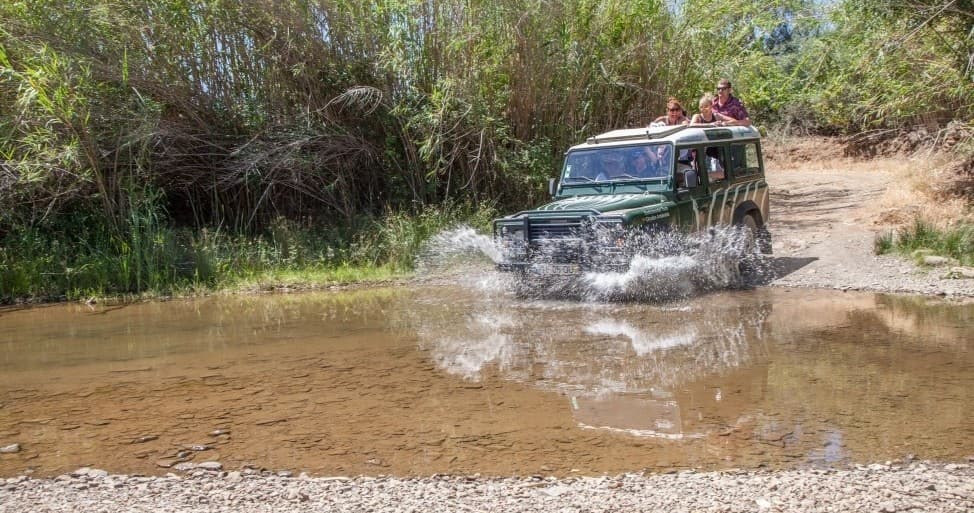 Off-road 4x4 splashing through river crossing on nature trail