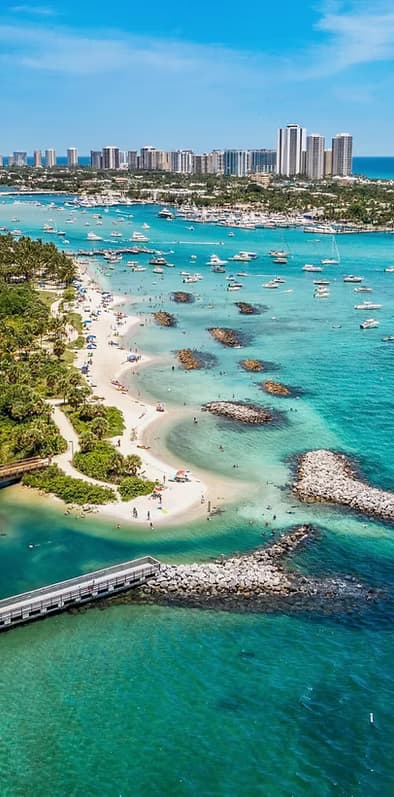Aerial turquoise beach with boats in tropical bay