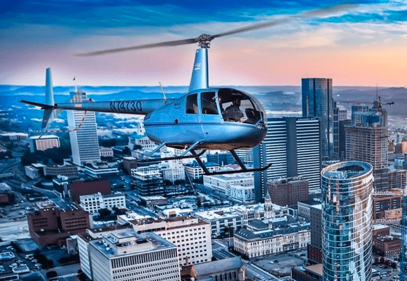 Helicopter sightseeing flight over urban skyline at sunset