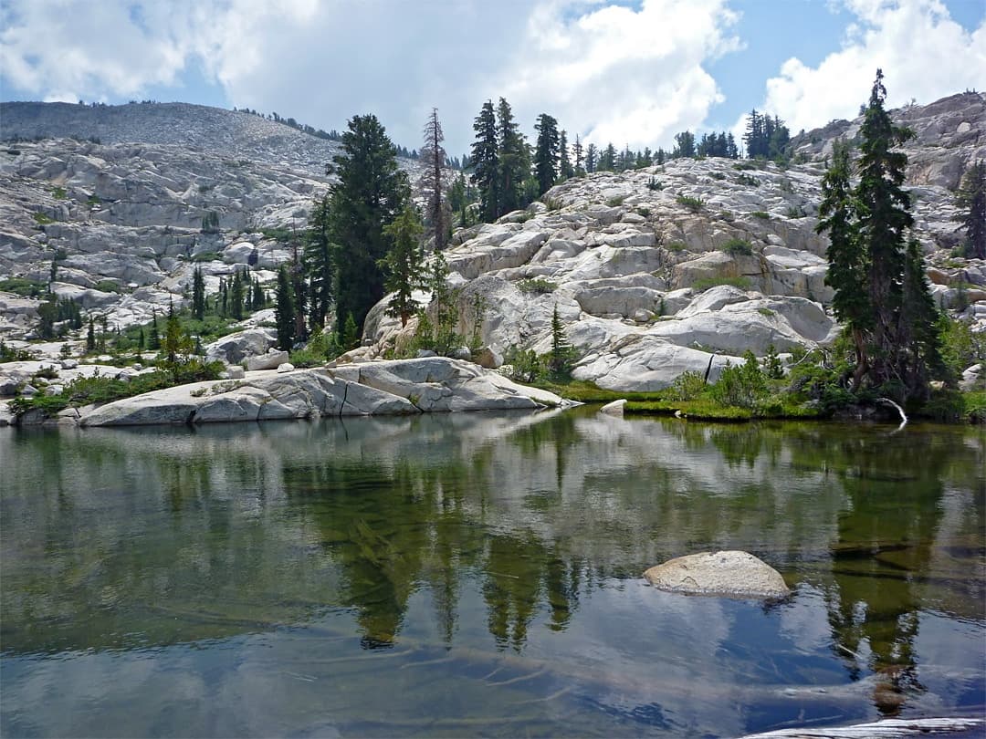 Alpine mountain lake reflecting granite slopes and pines