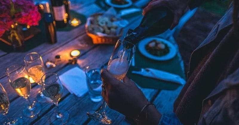 Outdoor twilight dinner with wine glasses and candlelit table