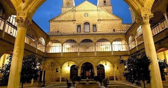 Historic cloister courtyard lit at night, guided cultural tour