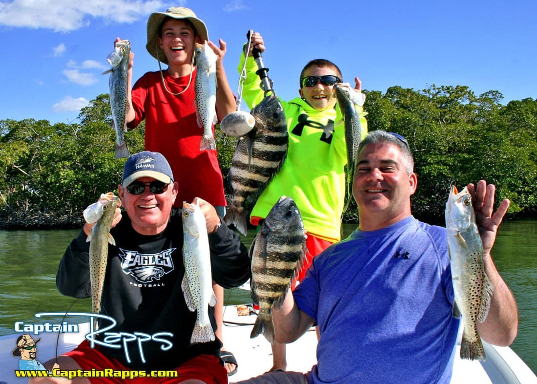 Family holding multiple catches on a charter in mangrove coastal waters