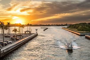 Motorboat speeding through Sarasota channel at sunset