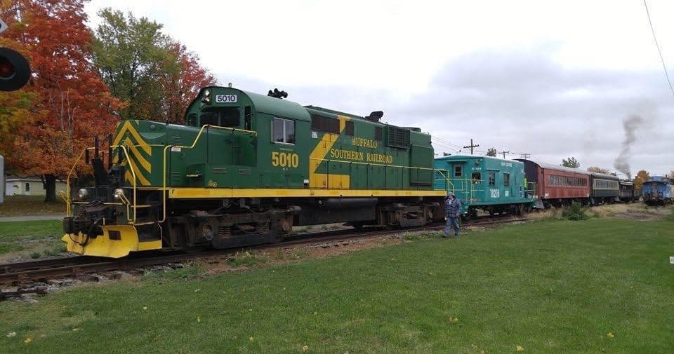 Heritage diesel locomotive parked by grassy field for scenic tour