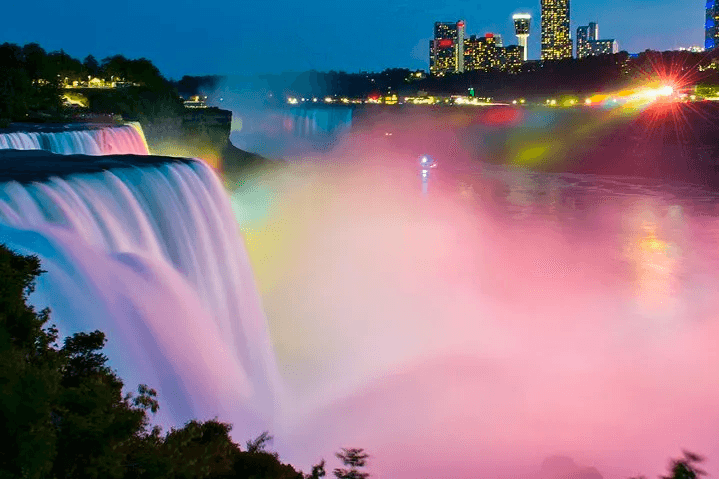 Illuminated Niagara Falls at night with vibrant rainbow lights