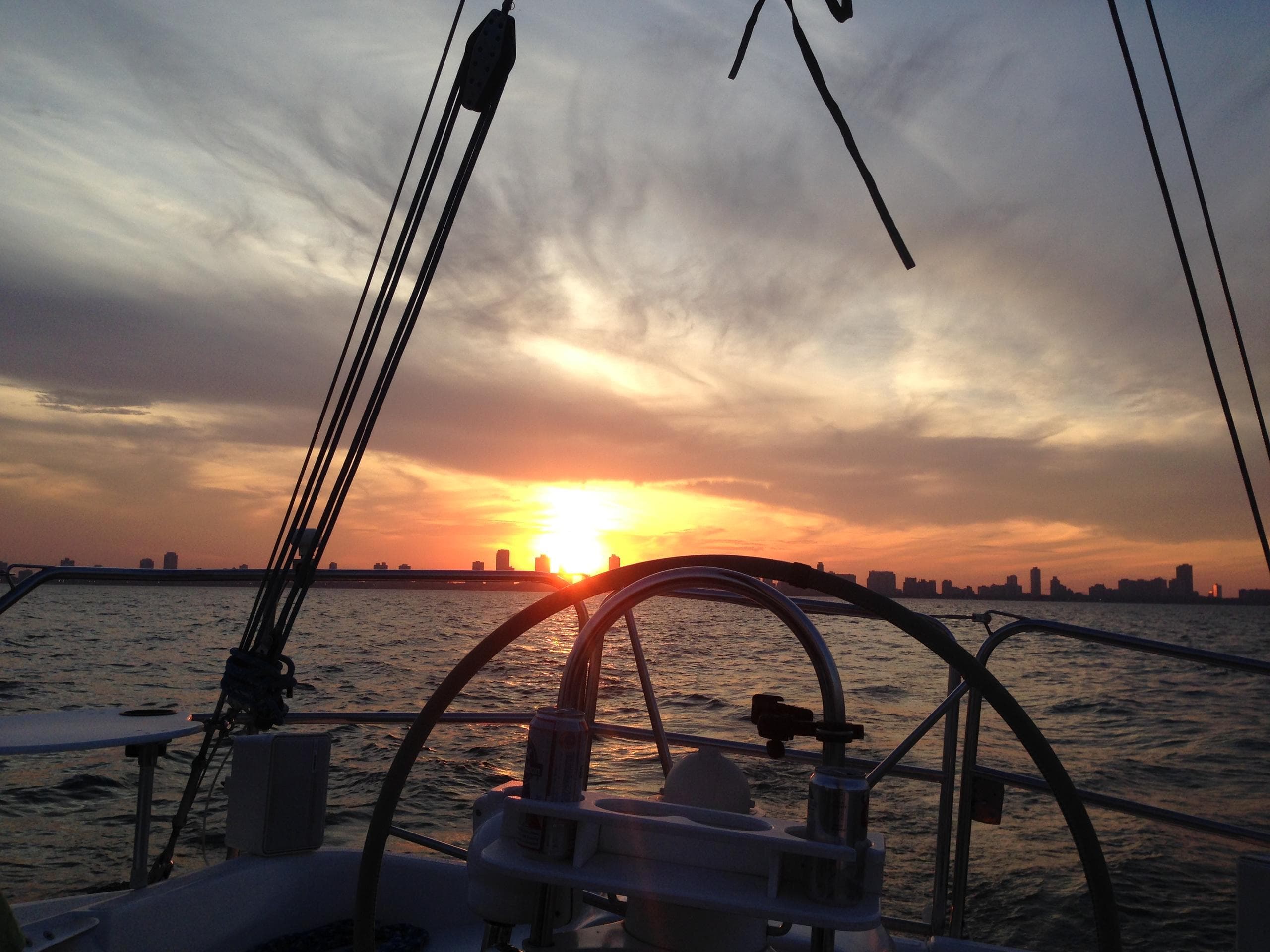 Sunset sailing helm silhouette over Lake Michigan skyline