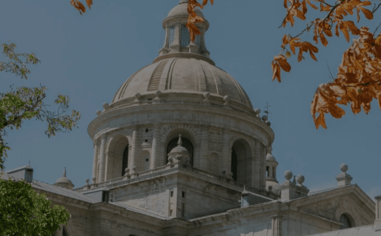 Gran cathedral dome framed by autumn leaves, panoramic city view