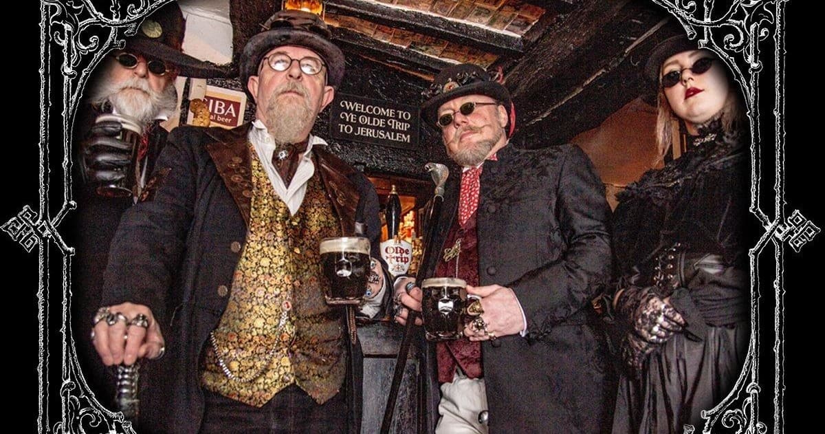 Group of costumed guides holding pints in Nottingham pub doorway