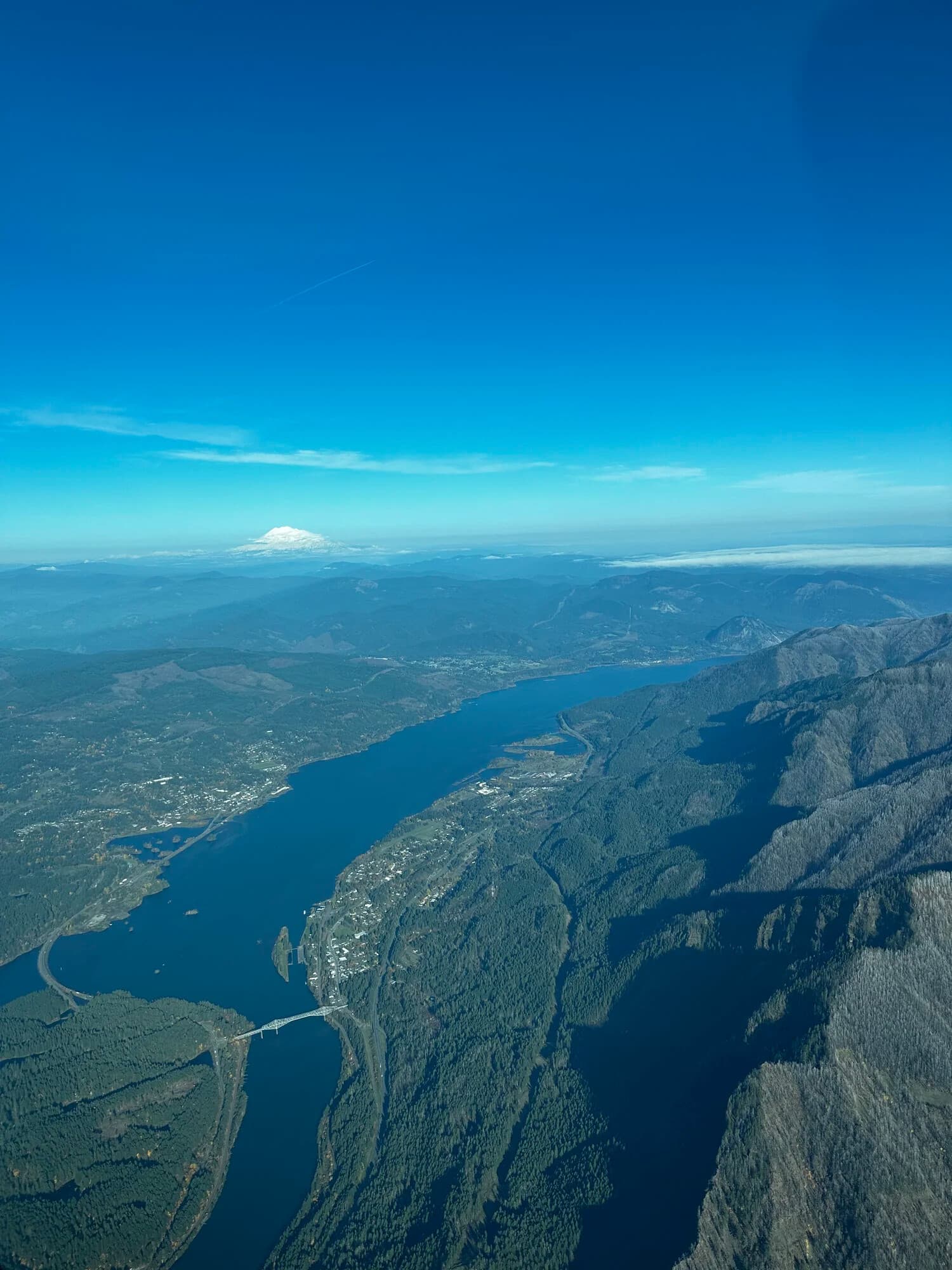 Panoramic aerial of river gorge and distant snow-capped peak