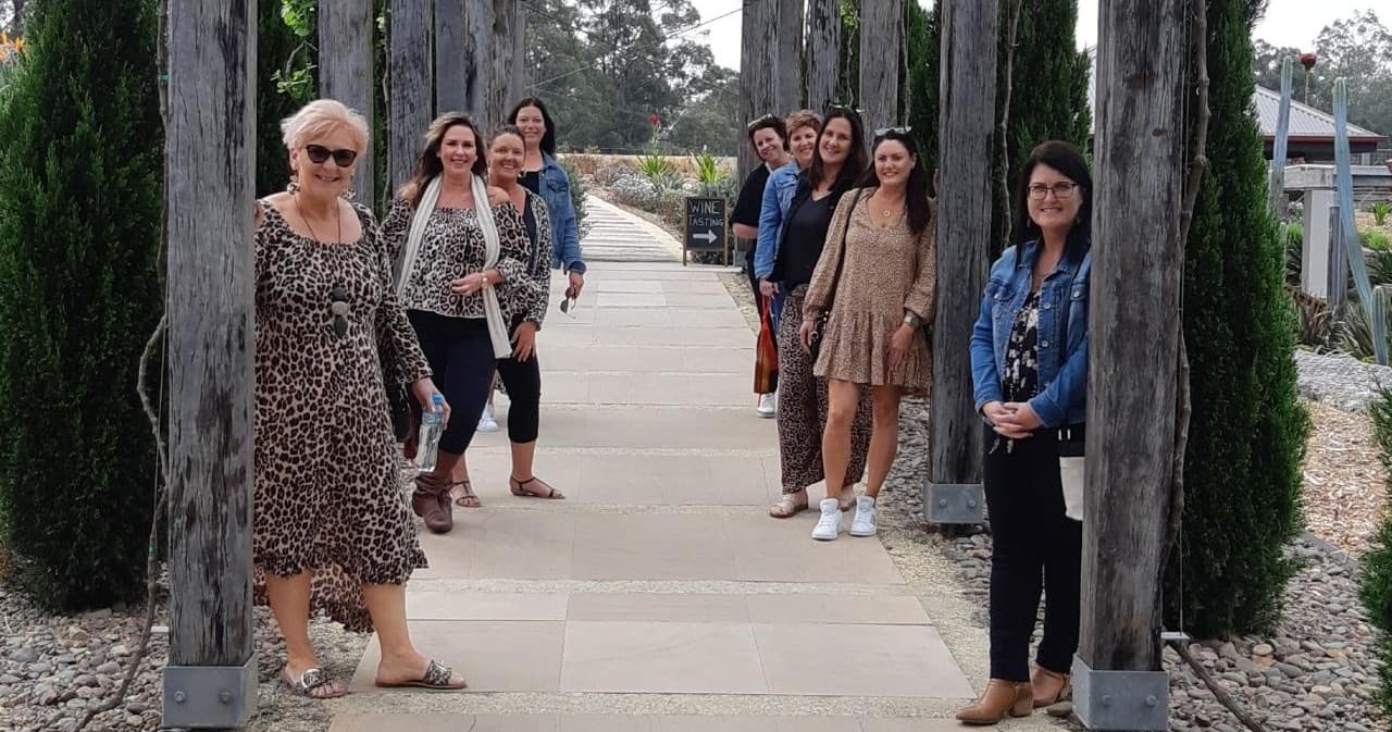 Group walking a winery courtyard lined with cypress trees