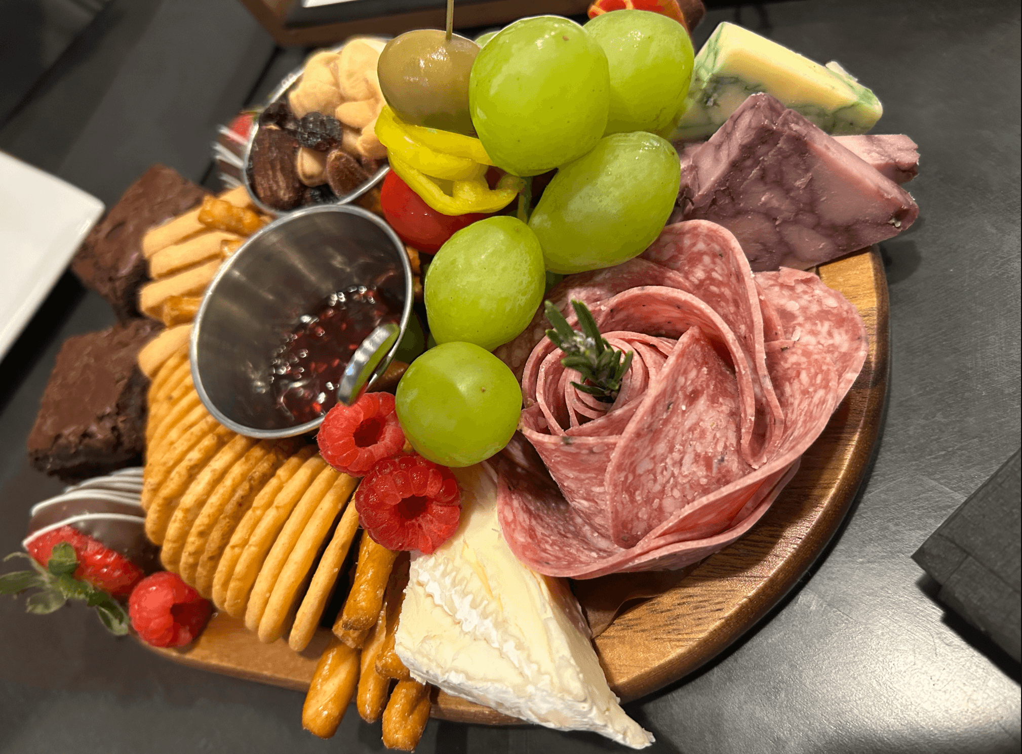 Artisan charcuterie board with cheeses and grapes at indoor dining