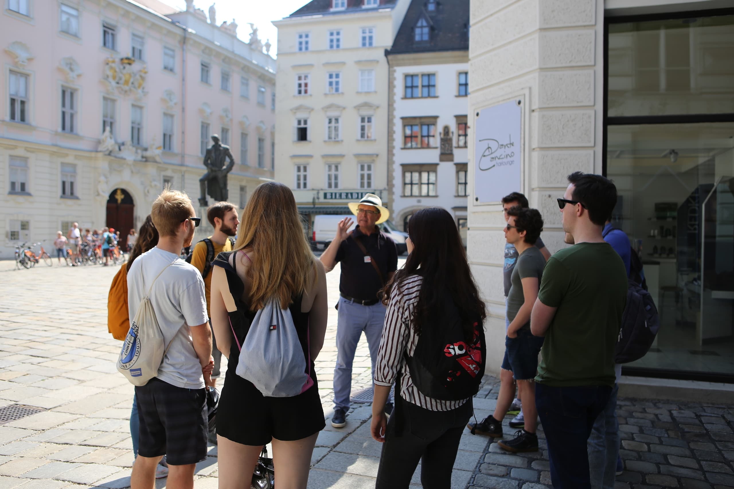Tour group listening to guide in Vienna historic plaza sightseeing
