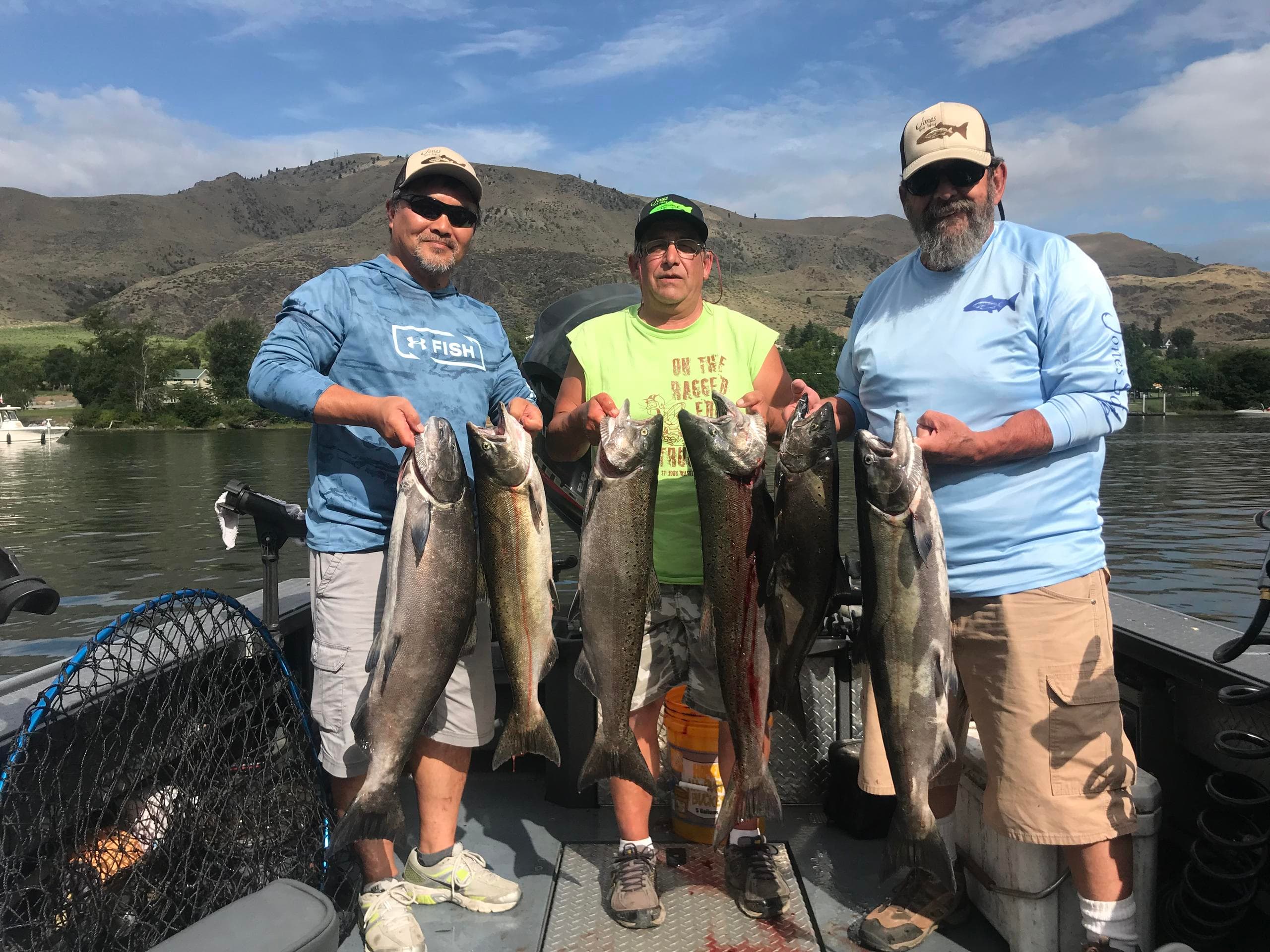 Group of anglers with multiple steelhead catches by shoreline