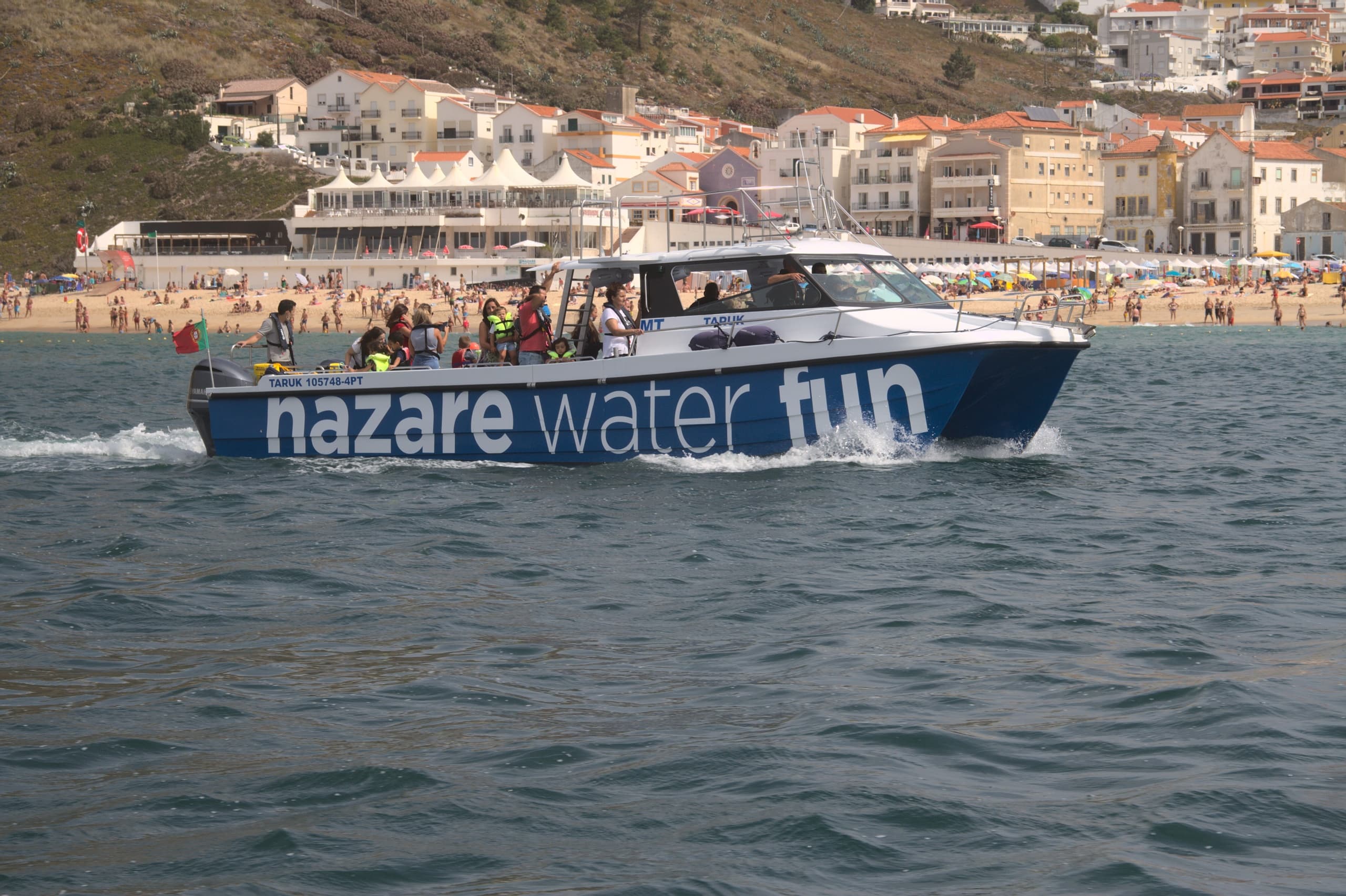 High-speed tour boat labeled Nazare Water Fun on coastal waters