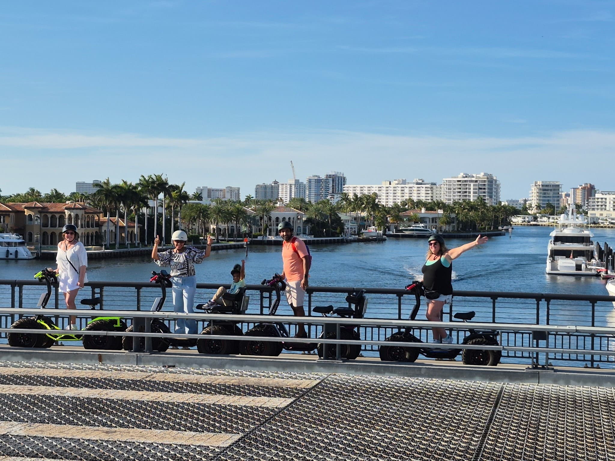Family e-trikes on grass by Fort Lauderdale waterfront sunset