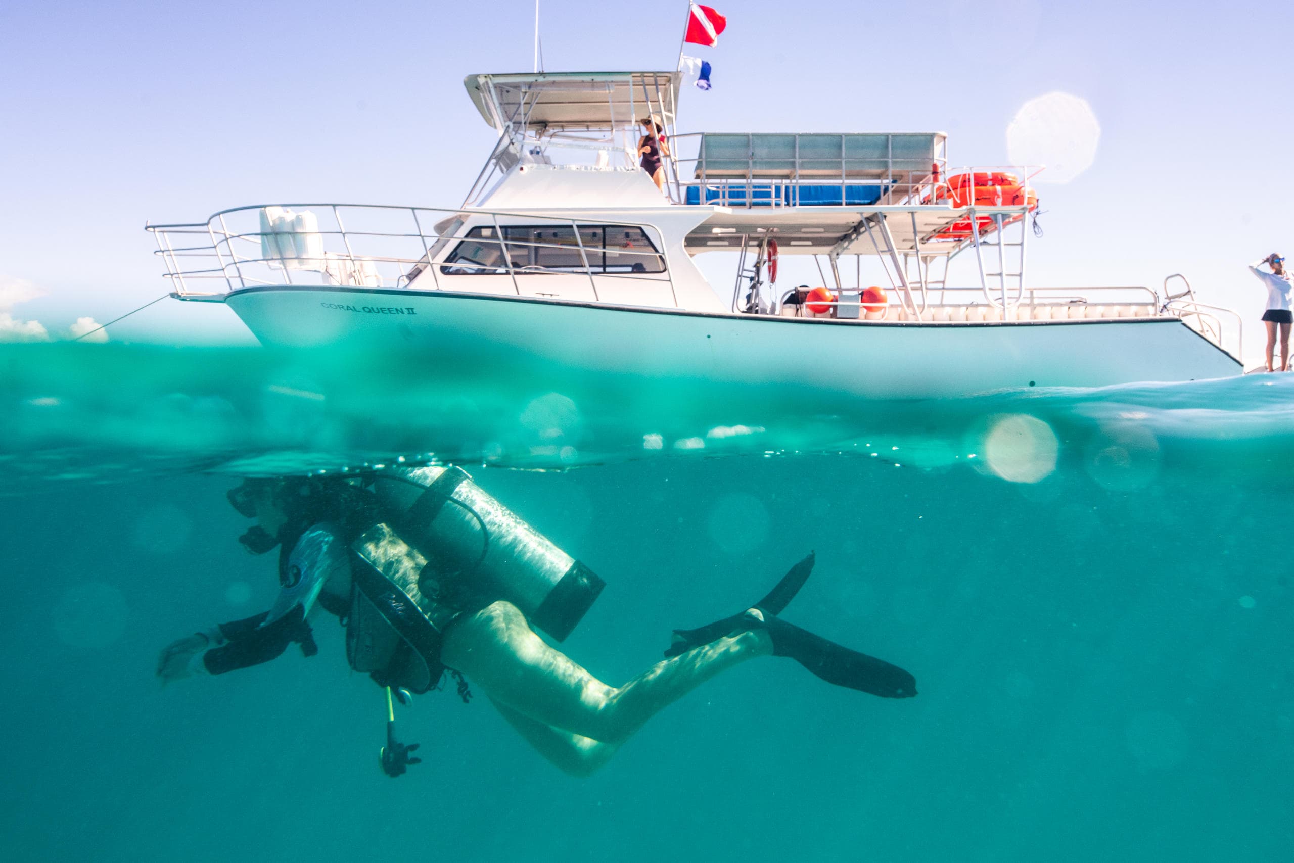 Diver surfacing near dive boat in clear Caribbean water