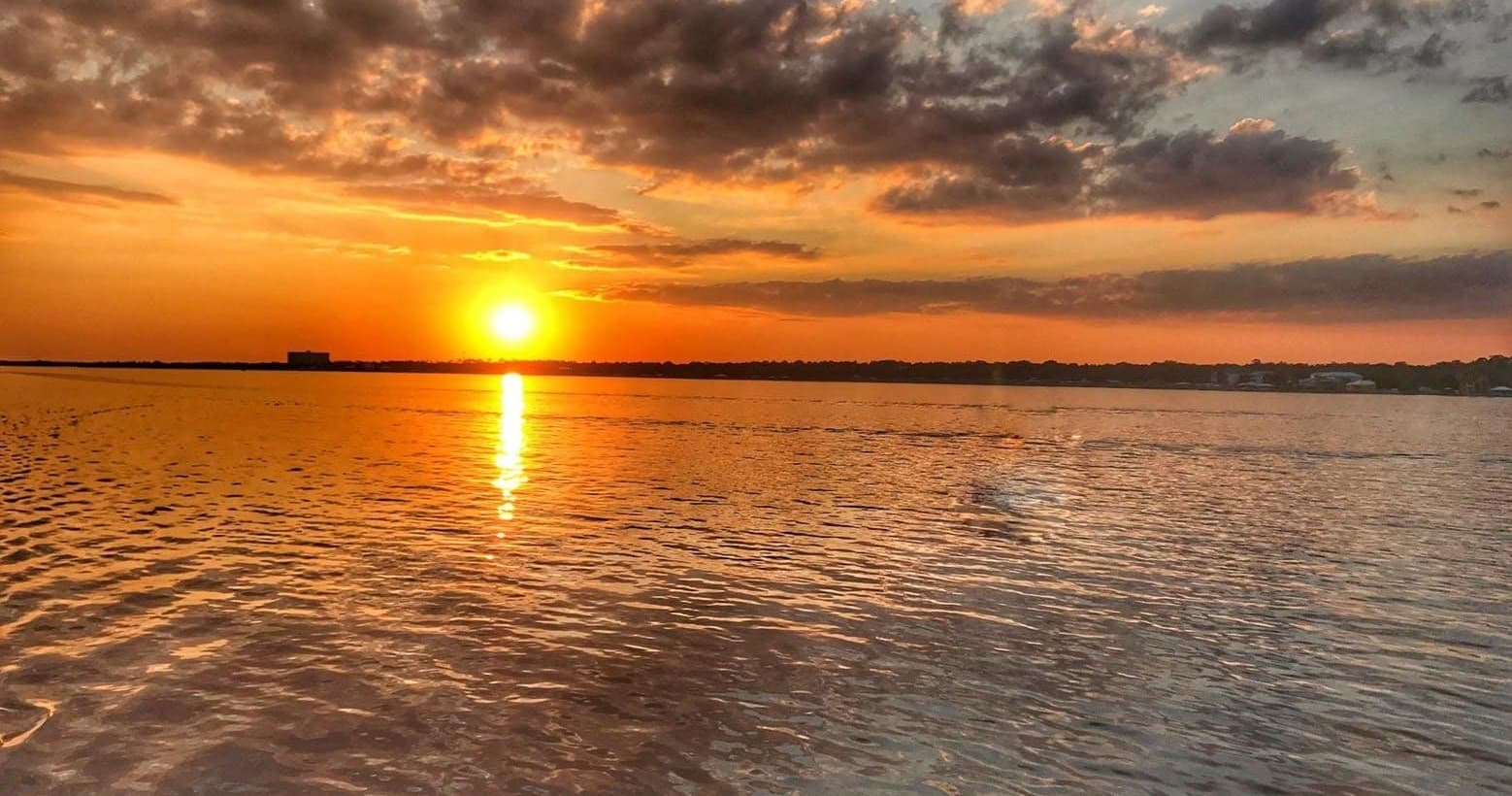 Golden sunset over open river waters, scenic calm waterfront