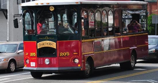 Red Salem trolley driving through historic street for sightseeing