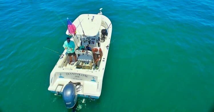 Aerial view of fishing boat on clear turquoise coastal waters