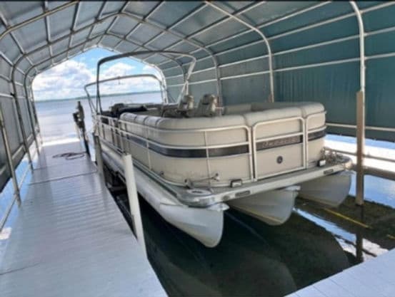 Pontoon rental docked in covered boathouse on freshwater lake