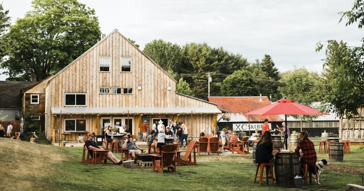 Outdoor brewery beer garden with picnic tables at Maine farm