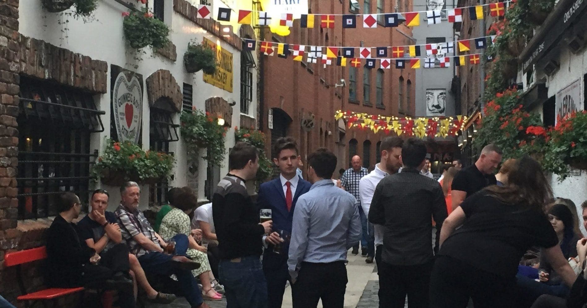 Bustling pub alley with outdoor seating on Belfast cobblestone street