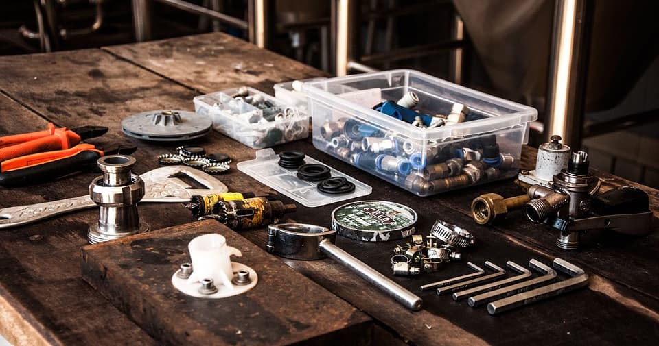 Close-up of plumbing tools and fittings on a workshop bench indoors