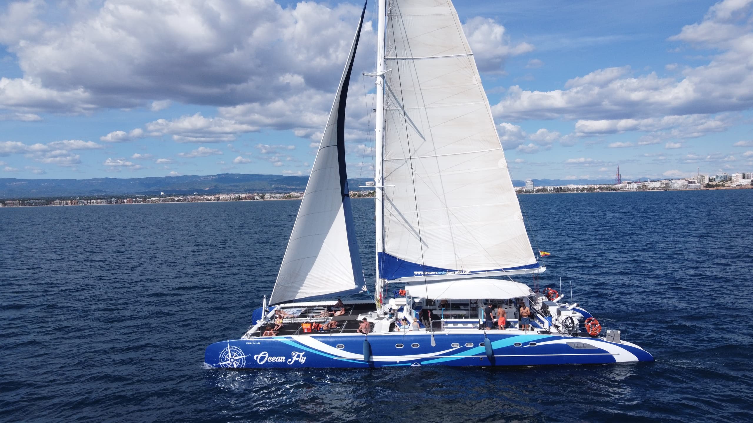 Large sailing catamaran with passengers off Costa Dorada coast