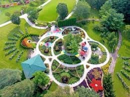 Aerial view of circular garden park trails in lush green landscape