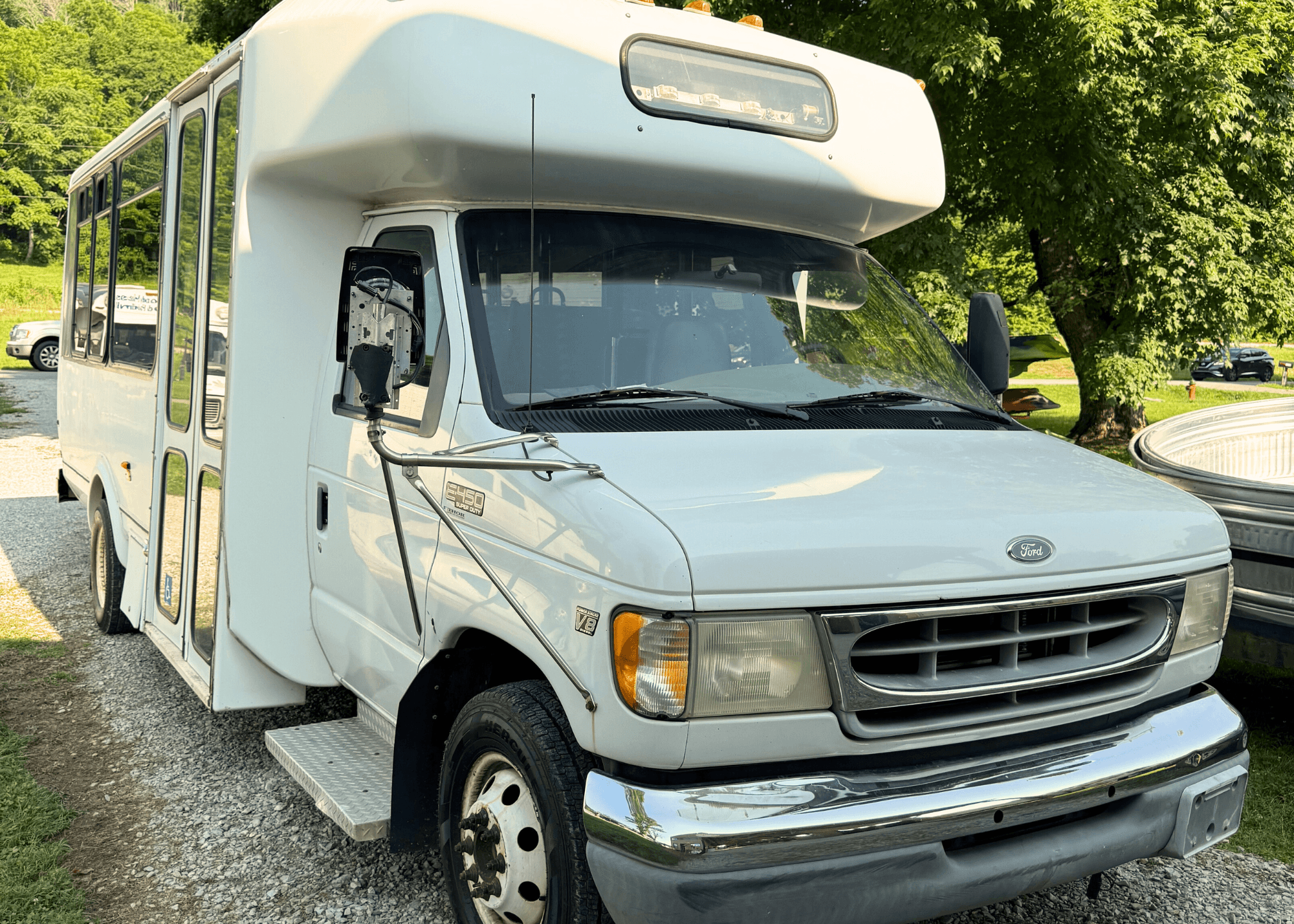 White shuttle van parked at river rental lot for group transport