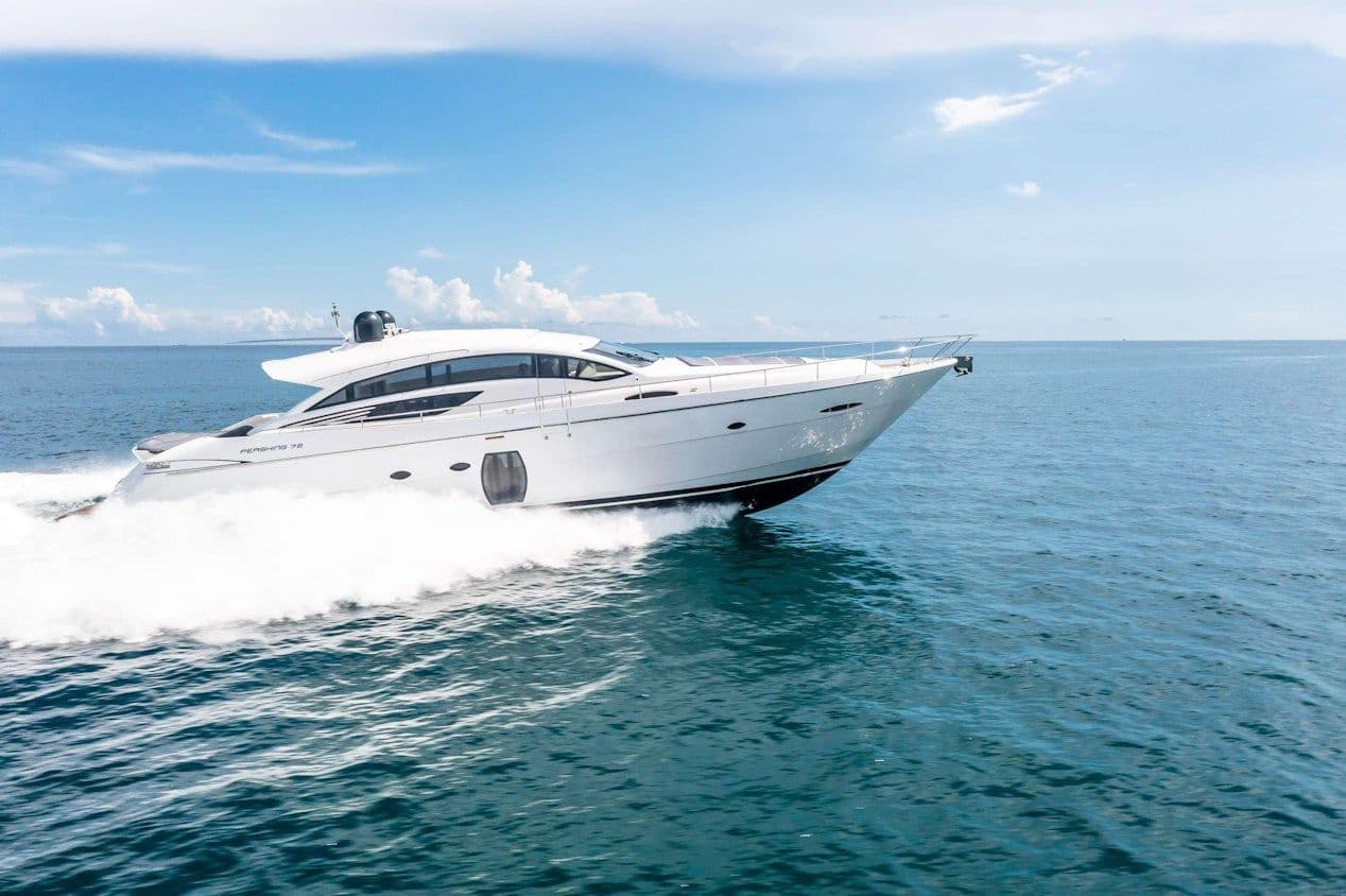 White motor yacht speeding across open sea near coastline