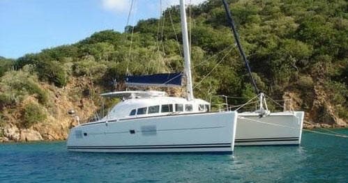 Catamaran anchored near green shoreline in calm coastal bay