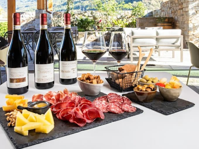 Outdoor tasting setup with wine and charcuterie on terrace