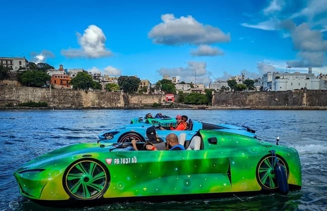 Green amphibious sports car cruising coastal shoreline waters
