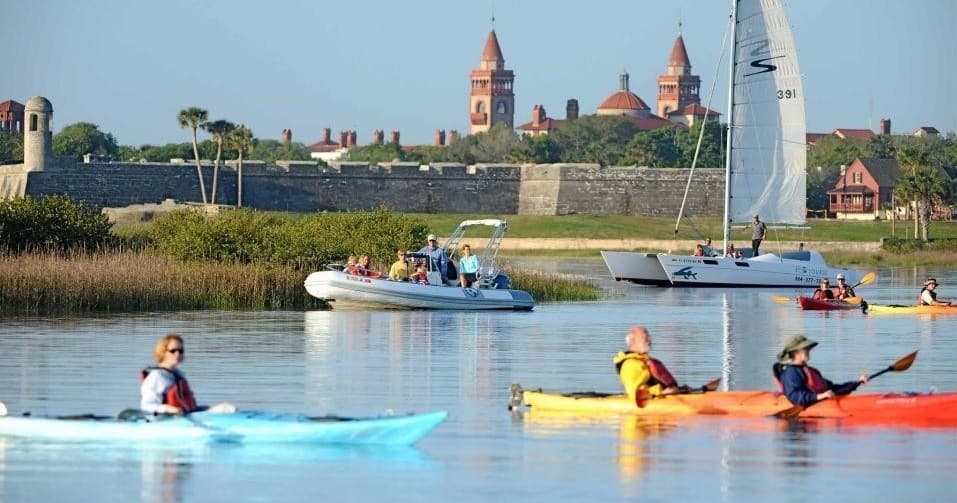 Kayakers paddling past historic shoreline and waterfront skyline