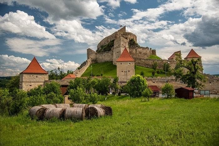 Historic hilltop castle overlooking green meadow hiking routes