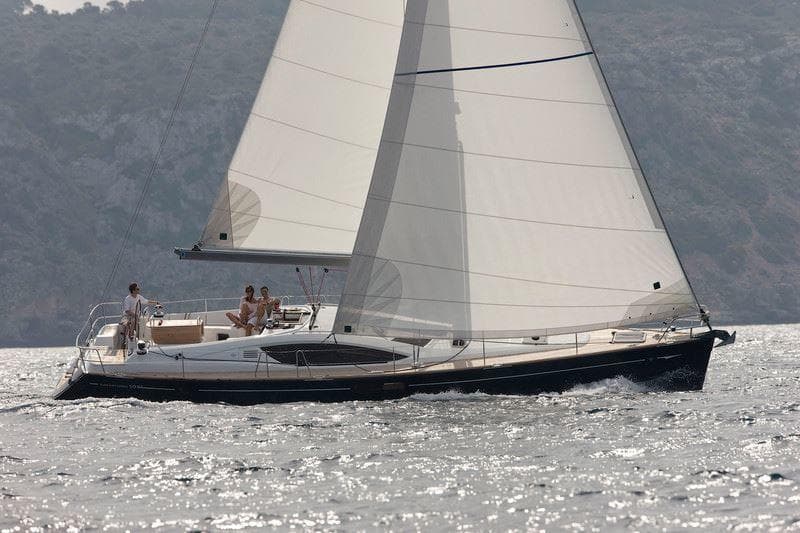 Spacious sailing yacht cruising coastal waters on sunny day