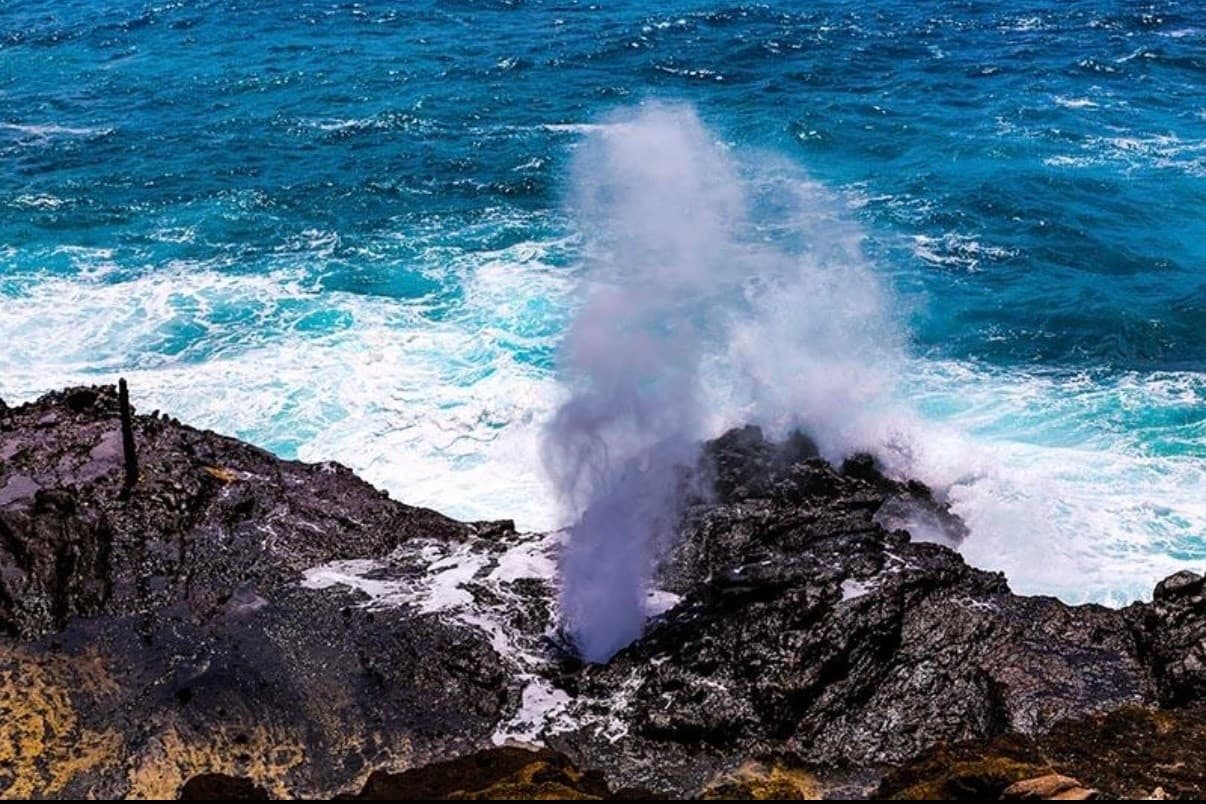Ocean waves forcefully erupting through coastal blowhole, Oahu