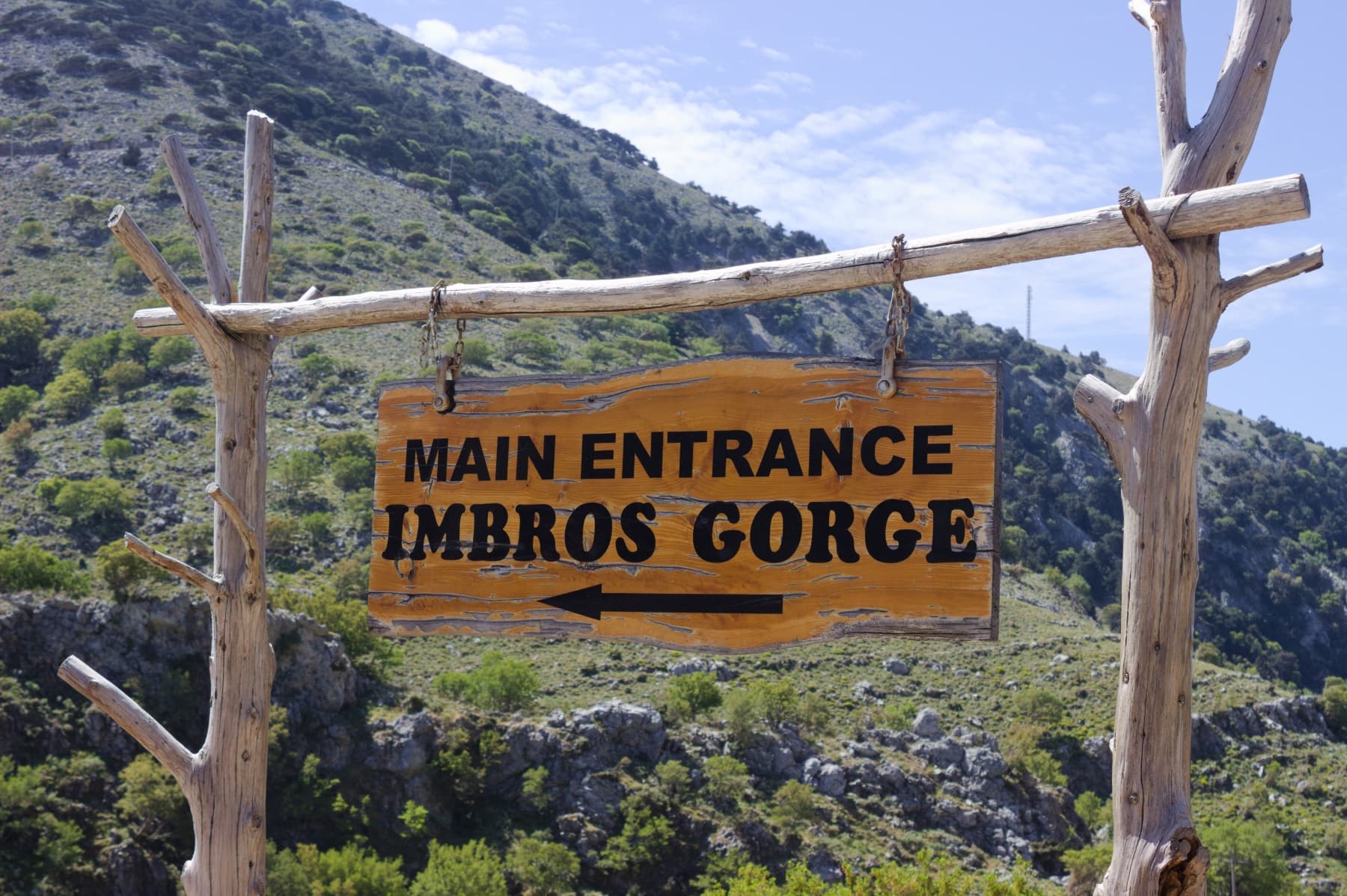 Main entrance sign to Imbros Gorge trailhead in rugged mountains