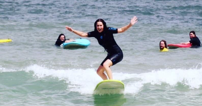 Surfer balancing on longboard near shore at Mandurah beach
