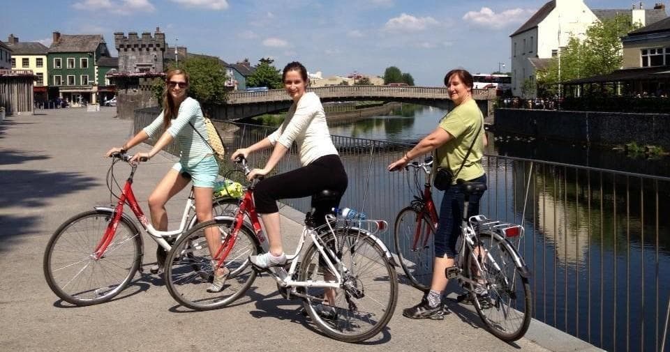 Leisure cyclists riding along Kilkenny canal on sunny day