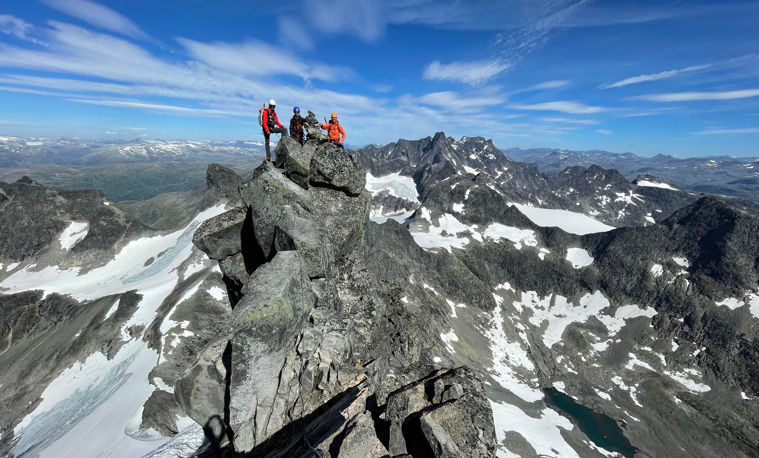 Hikers on rocky alpine ridge with panoramic mountain views