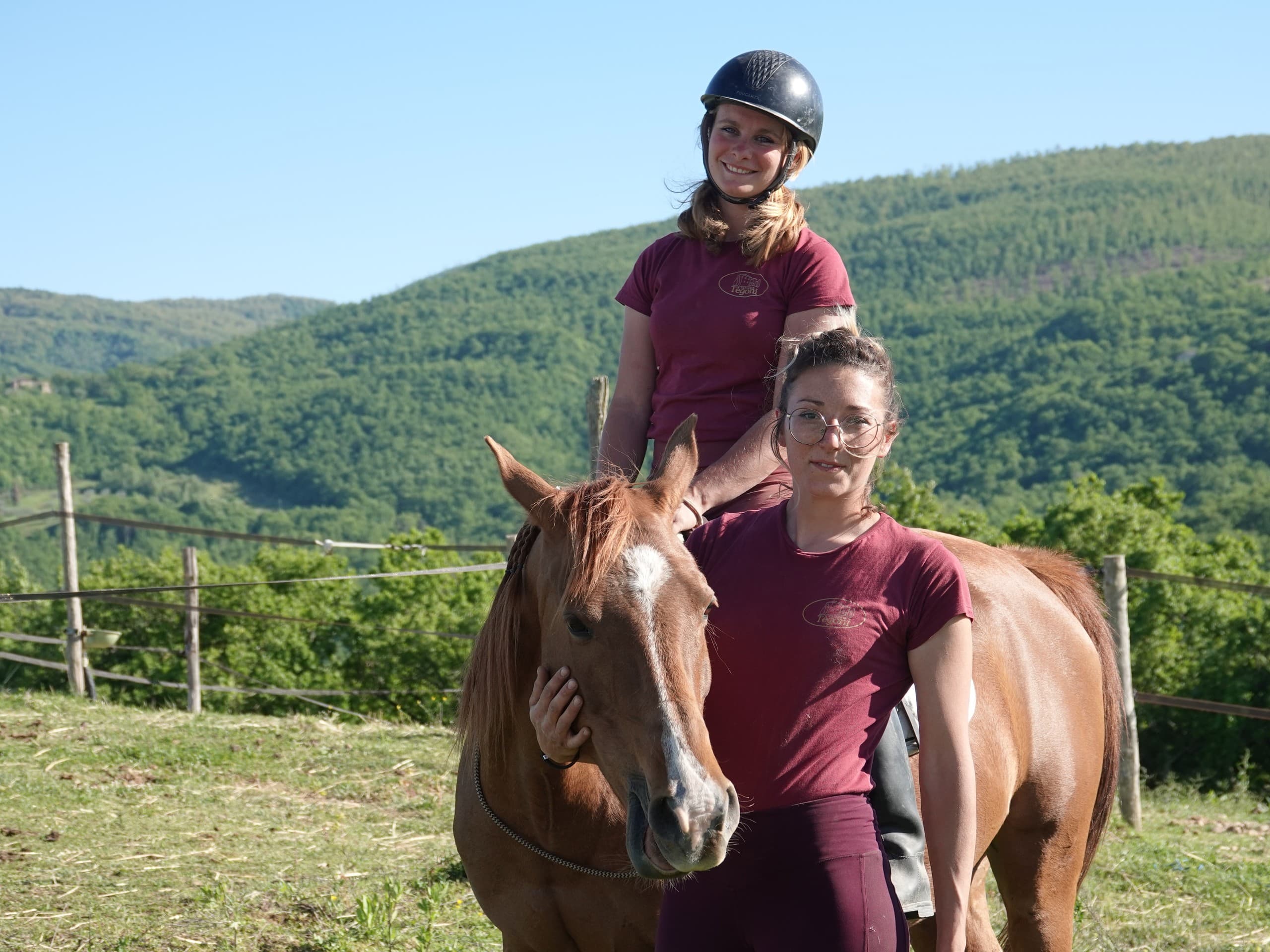 Woman with horse in rolling Tuscan hills near farm