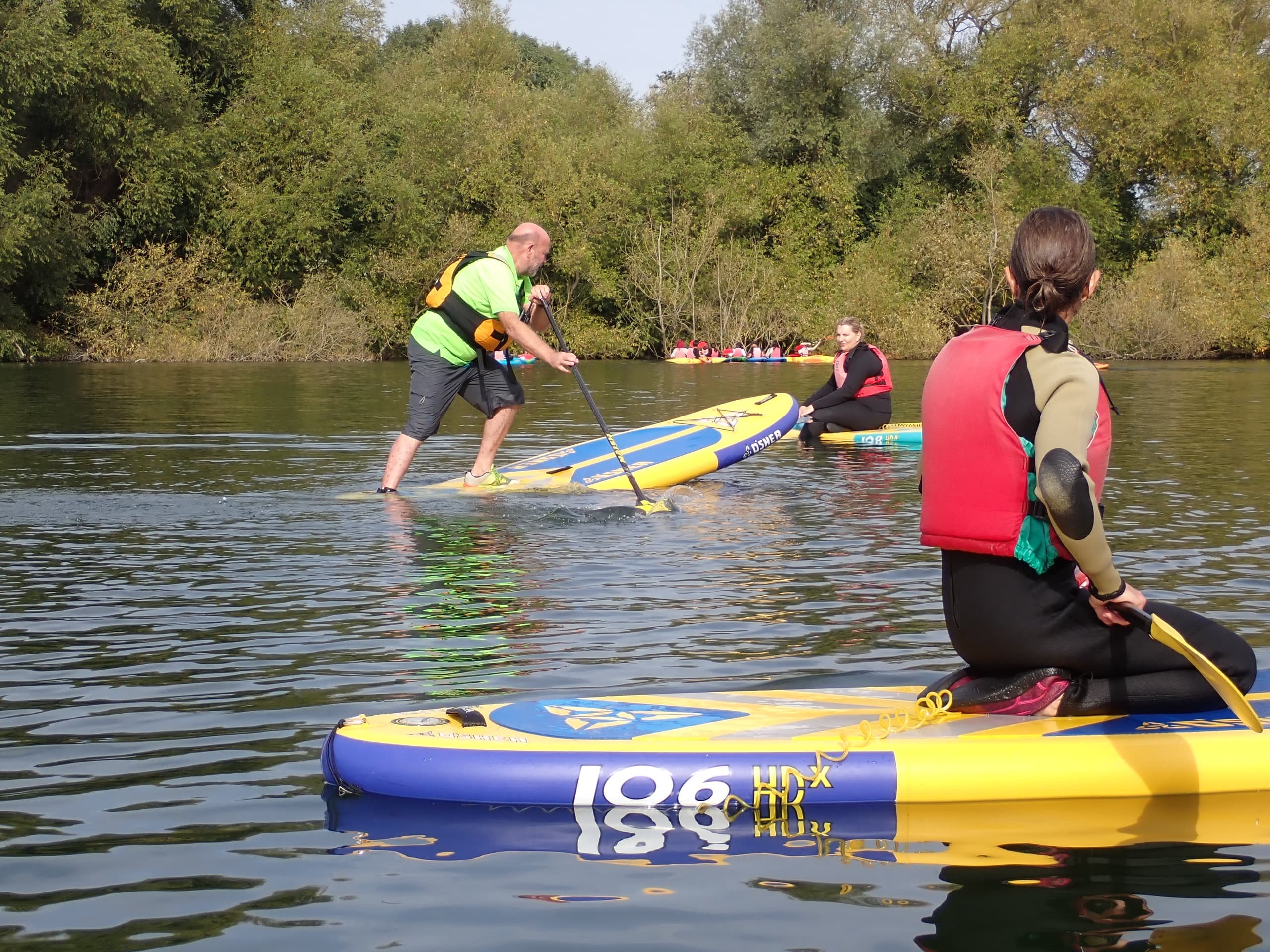 Stand-up paddleboarders practicing on a calm river setting