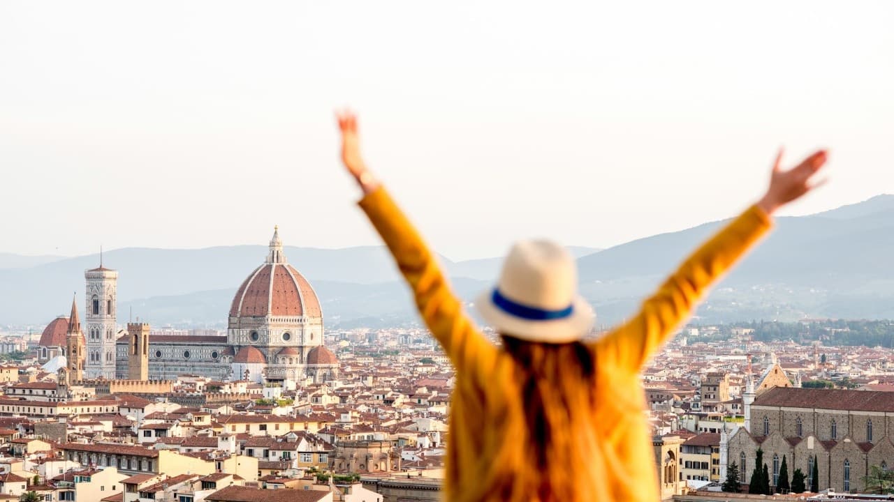 Traveler celebrating over Florence skyline with Duomo view