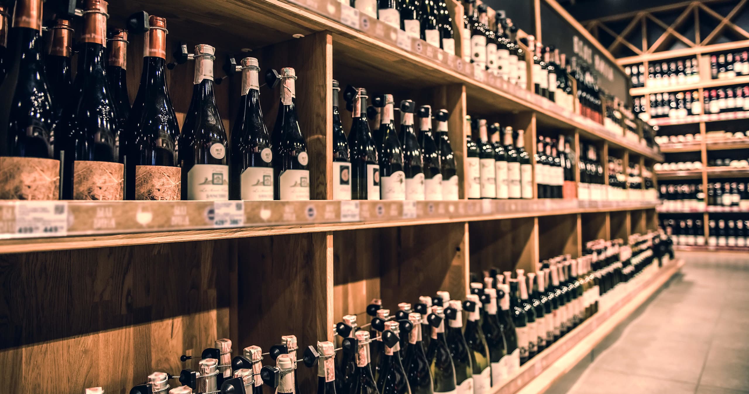 Shelves of wine bottles in Sutton Estate cellar, polished wood aisles