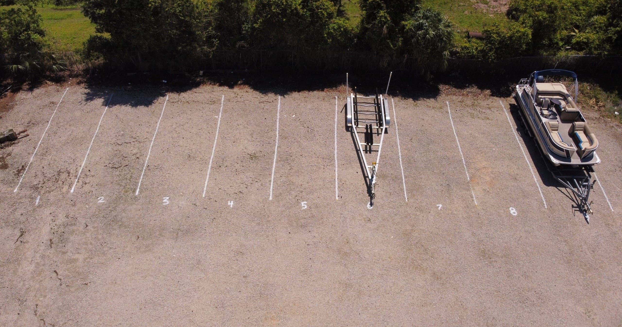 Aerial view of boat trailers parked on coastal gravel lot