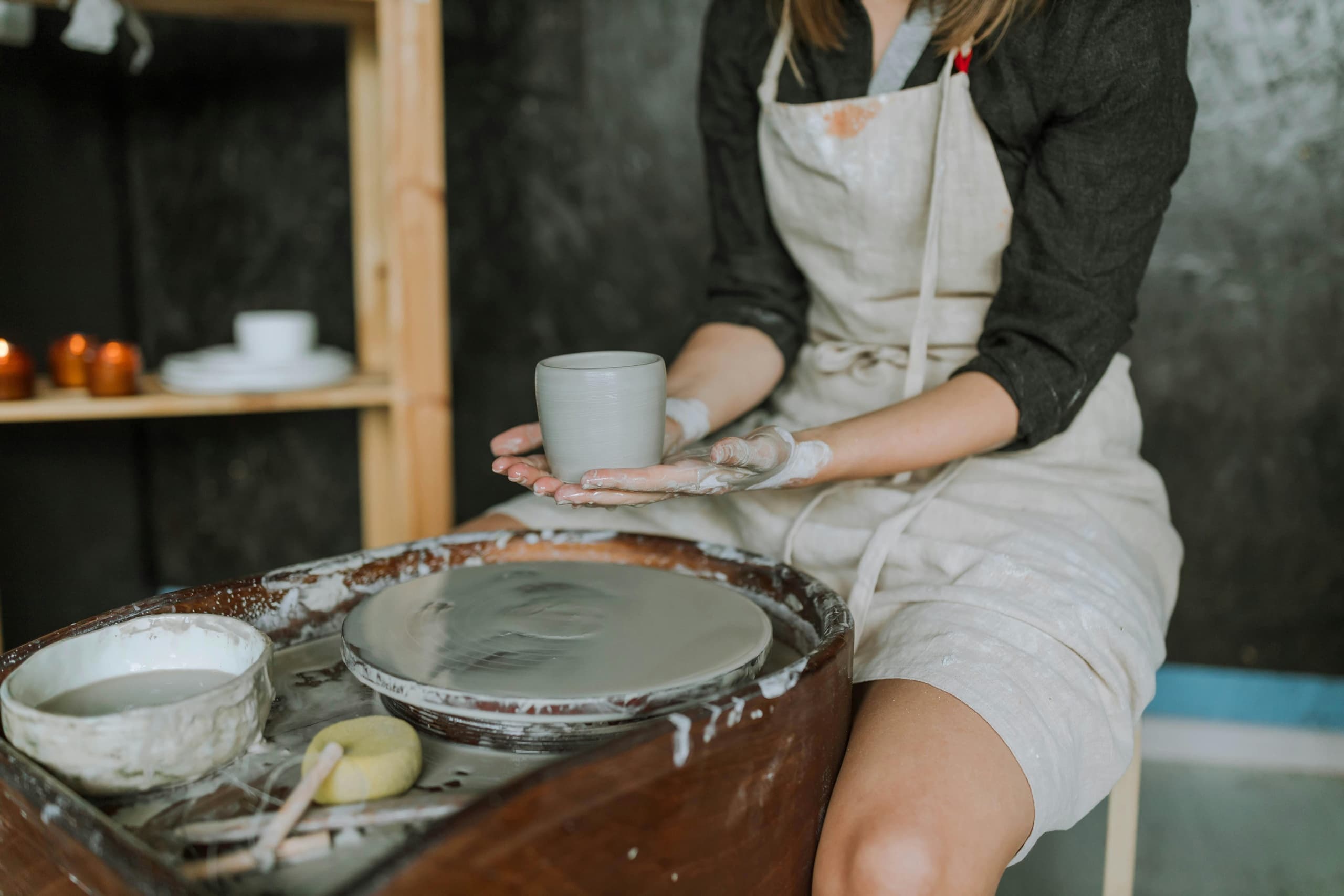 Potter throwing clay on wheel in ceramic studio workshop