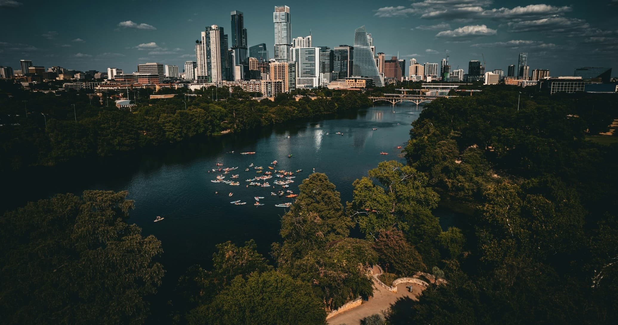 Downtown skyline over expansive lake with docks and trees